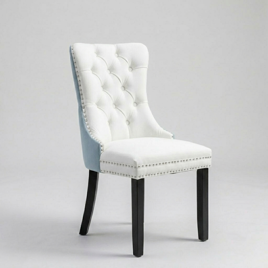 A high-back tufted dining chair with white upholstery, a light blue side panel, black legs, and silver nailhead trim, photographed on a light gray studio background.