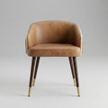 A mid-century modern accent chair with a warm tan leather seat and curved backrest, supported by dark wood legs with polished brass caps, set against a neutral gray studio background.